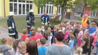 Bild: ohr
Kürzlich probte der Kindergarten St. Christophorus Stulln in einer Brandschutzübung den „Ernstfall“.Im Anschluss interessierte vor allem die Ausrüstung des Atemschutzträgers die Drei- bis Sechsjährigen. Der Zweite Kommandant der örtlichen Feuerwehr, Christoph Bierner (rechts), beantwortete im Beisein von Kindergartenleiterin Sabine Maderer (rechts außen) die zahlreichen Fragen.