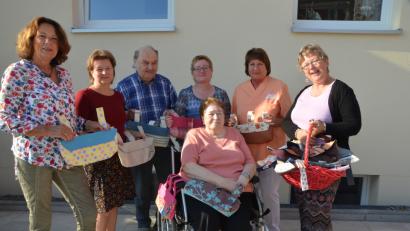 Bild: dob
Mit einem Korb voller handgenähter Rollstuhltaschen überraschen Helga Wondrak aus Moosbach (links), Karin Wappmann (rechts) und Lydia Gajan (Dritte von rechts) die Rollstuhlfahrer im Walter-Siegert-Caritasheim. Bewohnerin Elisabeth Kindl sichert sich gleich eine.