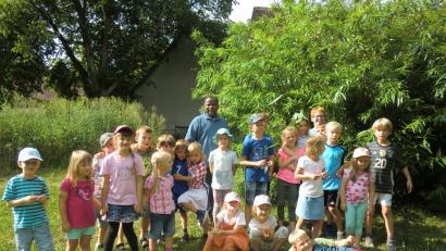 Bild: bas
Die kleinen Entdecker des Obst- und Gartenbauvereins Freudenberg/Wutschorf auf der Obstwiese des Pfarrgartens Wutschdorf mit Pfarrer Moses Gudapati.
