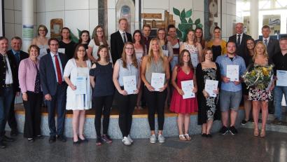 Bild: Bühner
Eingerahmt von Ehrengästen freuen sich die Preisträger an der Europaberufsschule Weiden über ihre Urkunden.