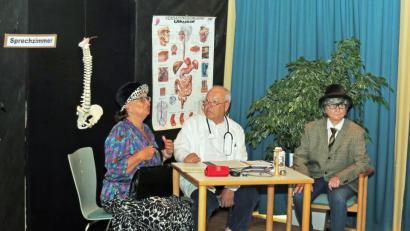 Bild: Dobmeier
Die Frau (links Jutta Wolfrath) gibt große Gesundheitsdiagnosen und ihr Mann (rechts, gespielt von Erni Liebwein) kommt nicht zu Wort. Da hat der Doktor (Axel Poy) ein Rezept verschrieben – eine neue Frau, zum Gelächter der begeisterten Gäste des Theaternachmittags der „MimOldies“. Bild: Dobmeier