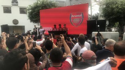 Bild: Christoph Sator/dpa
Bei einer Autogrammstunde des FC Arsenal in Singapur zeigt ein Fan ein Nationaltrikot von Mesut Özil (auf dem Podium, rechts). Zu seinem Rücktritt und seinen Vorwürfen sagte er nichts.