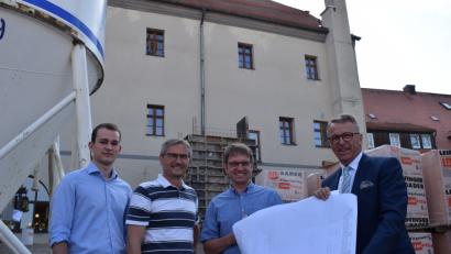 Bild: szl
Hinterhalb vom historischen Rathaus tut sich was. Die Baustelle des Anbaus wächst langsam in die Höhe, vor allem ist bereits der Aufzugschacht im Hintergrund zu sehen. Azubi Nico Wiesend, Architekt Thomas Sticht, Stadtbaumeister Andras Ockl und Bürgermeister Franz Stahl (von links) machen sich ein Bild von der Baustelle.