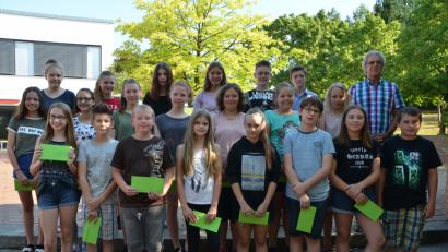 Bild: dob
Mittelschulrektor Alfons Raab (hinten, rechts) zeichnet seine besten Schüler aus. Kimberly McGibbon (vorne, links) ist mit einem Notendurchschnitt von 1,2 Schulbeste.