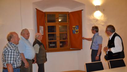 Bild: gi
Die Wappenvorhänge im Saal eignen sich zu einem Gang durch die Burg- und die Schlossgeschichte und ermöglichen Lichtbildervorträge auch während der Tageszeit. Mitglieder des Vorstands des Fördervereins sehen sich mit Bürgermeister Hermann Ach die Wappen an.