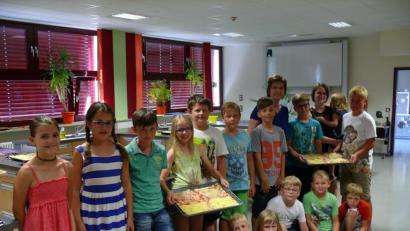 Bild: kgg
Bevor die Bleche in den vortemperierten Ofen geschoben wurden, präsentierten die kleinen Pizzabäcker ihre Kreation. Im Bild mit Leiterin Gabi Kohl und Tochter Susanne mit Töchterchen Hanna auf dem Arm.