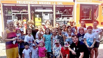 Bild: R. Kreuzer
Die Feuerwehr besuchte Kinder bei der Arbeiterwohlfahrt zum Ferienprogramm. Hilde Zebisch gab an die Jugendfeuerwehr eine Spende der AWO.