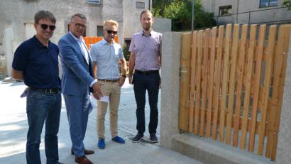 Bild: szl
Stadtbaumeister Andreas Ockl, Bürgermeister Franz Stahl, Straßenbaumeister Michael Dörfler und stellvertretender Kämmerer Harald Eckstein (von links) begutachten das Ergebnis des altstadtgerechten und barrierefreien Ausbaus der Ringstraße. Die Gruppe steht an der engsten Stelle der Straße, die vor der Sanierung noch enger war. Durch den Abriss eines baufälligen Hauses konnten etwa 60 Zentimeter für die Altstadtgasse gewonnen werden. Jetzt passen auch Rettungs- oder Müllfahrzeuge durch das Nadelöhr. Auf dem Grundstück dahinter entstehen begrünte Parkplätze.