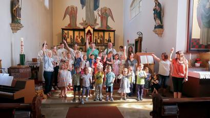 Bild: bsc
Mädchen und Buben des Kinderhauses Friedenfels gestaltete zusammen mit Priester Siegfried Wölfel (hinten) einen Familiengottesdienst und verabschiedete sich vor der gesamten Kirchengemeinde in die Ferien. Kindergartenleiterin Nicole Lippert (hinten Mitte) dankte den Geistlichen.