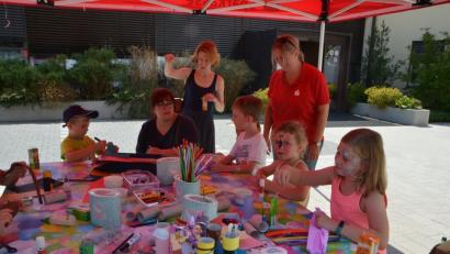 Bild: dob
Zum Auftakt des Kinderferienprogramms war es noch nie so heiß wie in diesem Jahr. Trotzdem kommen die Mädchen und Buben gerne zur Sparkasse und basteln lustig drauf los. Evi Halscheidt (hinten, rechts) organisierte den Nachmittag.