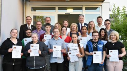 Bild: (exb)
Die Ehrengäste gratulieren zur abgeschlossenen Berufsausbildung (von links): Bürgermeister Martin Preuß, Martin Gimpl (Kolping), Manfred Tröppl (Geschäftsstellenleiter Agentur für Arbeit), Sonja Schleicher (Geschäftsführerin Jobcenter), Andrea Ziegler (Zentrumsleiterin Kolping-Bildungswerk), Landrat Richard Reisinger und Robert Pirner (Teamleiter Kolping).