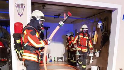 Bild: mde
Unter Atemschutz gehen die Feuerwehrleute vor. Zur Sicherheit nehmen sie ein Strahlrohr mit das jedoch nicht zum Einsatz kommt. In Schuttmulden bringen sie das Brandgut aus dem Haus, damit es im Außenbereich abgelöscht wird.