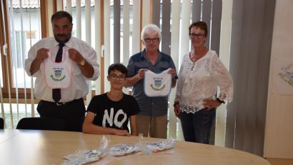 Bild: fla
Bürgermeister Josef Beimler (links) und Kämmerer Josef Götz (Zweiter von rechts) präsentieren die Geschenke für die Neugeborenen. Praktikant Tobias Sollfrank (sitzend) fertigte passende Urkunden und Petra Reil (rechts) verpackte die Lätzchen.