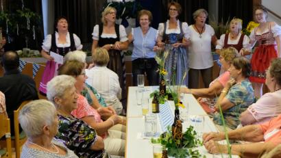 Bild: le
Kräftig gesungen und geschunkelt wird zu den G'stanzeln, die Brigitte Beer (stehend, links) mit ihrem Team vorträgt.