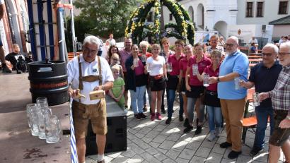 Bild: ui
Die Bedienungen und Organisatoren warten mit leeren Krügen, während Bürgermeister Rupert Troppmann das erste Fass für das Zoiglfest am Stadtplatz anzapft.