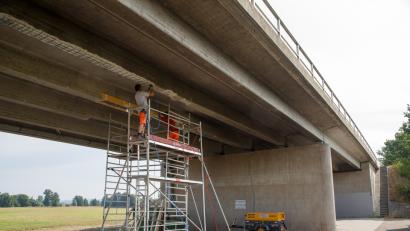 Bild: Hösamer
Unter der Brücke ist ein Gerüst aufgestellt, das Team der Firma "Strabag"arbeitet an zwei der sechs Träger der Spanngliedbrücke.
