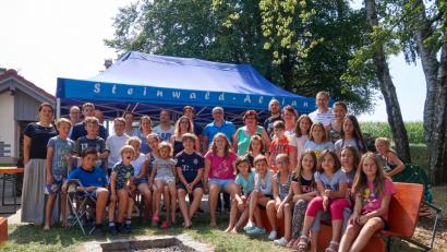 Bild: njn
Das Dorfgemeinschaftshaus in Lochau mit seinen tollen Außenanlagen ist der perfekte Ort für das deutsch-tschechische Sommerlager. Besuch bekommen die Jugendlichen vom Geschäftsführer der Steinwald-Allianz, Martin Schmid (hinten rechts), und Pullenreuths Bürgermeister Hubert Kraus (hinten Mitte, mit blauem Hemd).