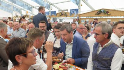 Bild: jzk
Am Biertisch tauschen sich Landtagsabgeordneter Tobias Reiß (vorne, Zweiter von links) und Ministerpräsident Markus Söder (ihm gegenüber) über weitere Möglichkeiten aus, die ländliche Region zu stärken.