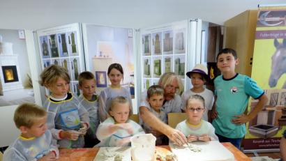 Bild: ubb
Josef Regner (Vierter von links) zeigt den Kindern, wie der Ton geknetet werden muss.