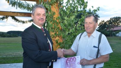 Bild: dob
Bürgermeister Andreas Wutzlhofer (links) kommt zur offiziellen Dorfplatzübergabe in Unterlind nicht mit leeren Taschen. Das freut insbesondere den Initiator und Dorfsprecher Alfred Uschold.