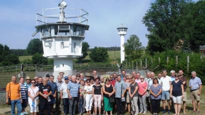 Bild: prp
Die Reisegruppe der FW Vilseck um Vorsitzenden Thorsten Grädler (links) vor den Wachtürmen des ehemals geteilten Dorfes Mödlareuth.