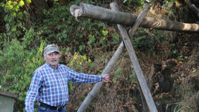 Bild: upl
Paul Schmidbauer am ausgetrockneten Lohbach. Normalerweise fällt hier das Wasser etwa drei Meter vom Hang herunter. Über den ausgehöhlten Stamm wird der Teich mit Frischwasser versorgt.