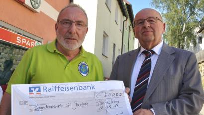 Bild: es
OWV-Vorsitzender Heino Henning (links) überreicht zu Beginn des Backofenfestes mit humorvollen Worten Pfarrer Wilhelm Bauer einen Scheck über 500 Euro für die Restaurierung der Wallfahrtskirche St.Jodok.