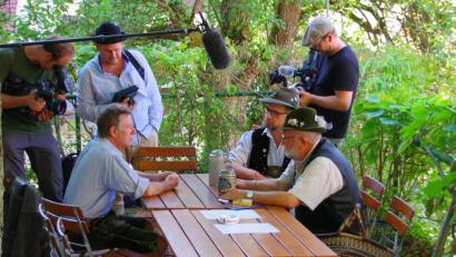 Bild: müb
Während sich (sitzend, von links) Stofferl Well, Hobbo Royer und Sepp Lösch angeregt über das Sudern unterhalten, fängt das Fernsehteam ihren Austausch in Bild und Ton ein.