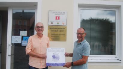 Bild: exb
Koordinator Jochen Sertl (links) und Vorsitzender Karl Lorenz präsentieren die Hinweistafel vor dem neuen Standort des GeHiH-Büros.
