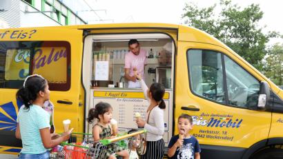 Bild: Gerhard Götz
Mit insgesamt drei Eismobilen – einem organgen, einem weißen und einem gelben – ist Salvatore in der Region unterwegs. Bei den hohen Temperaturen, die es in den vergangenen Monaten gab, sind seine Eiskugeln sehr beliebt. Wie bei dieser Familie. Mama und Kinder bekommen jeweils eine Kugel: Mango, Schoko, Banane und Zitrone.