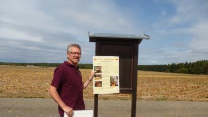 Bild: bk
Rudi Prölß vor dem Anbringen der sanierten Schautafel, zu Füßen die alte Tafel.