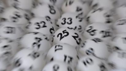 Bild: Arne Dedert
Lottokugeln liegen in einem Ziehungsgerät. Foto: Arne Dedert/Archiv