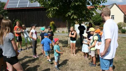 Bild: roh
Erwartungsfroh stellten sich bei herrlichem Wetter die Kinder am Dorfweiher zusammen, um die ersten „Briefe“ mit Botschaften und „Wundertüten" zu suchen. Rechts Organisator Daniel Hirschmann vom Jugendrotkreuz.