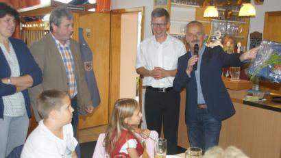 Bild: exb
Bürgermeister Hubert Zwack (rechts) überreicht an Pfarrer Johann Wutz (links daneben) ein Lauftrikot mit dem Wappen der Gemeinde.