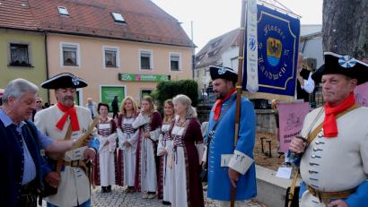 Bild: le
Der Oberste Dienstherr Bürgermeister Günter Stich und Hauptmann Franz Schmidt (von links) ernannten Roland Gmeiner (Mitte, mit Standarte ) zum Fähnrich der Flosser Landwehr.