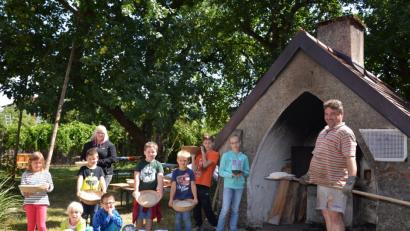 Bild: gi
Die Kinder haben ihr eigenes Brot selbst geknetet und zum Erkennen verziert. Dann schiebt Sandro Stefinger die Laibe in den Holzbackofen.