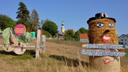 Bild: es
Die Einladung zum 13.Regionalmarkt in der Biodiversitätsgemeinde Tännesberg (im Hintergrund der Zwiebelturm der Pfarrklirche) neben der Infotafel "Wir sind Biodiversitätsgemeinde" am Ortsrand in der Großenschwandner Straße ist nicht zu übersehen.