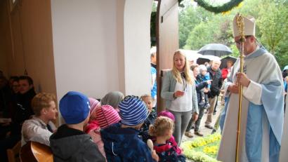 Bild: swo
Am Kirchenportal begrüßen die Mädchen und Buben des Gebenbacher Kindergartens mit ihrer Leiterin Gabi Neuberger (links) Weihbischof Josef Graf mit einem Lied.