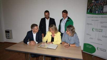 Bild: bjp
Nicht fehlen durfte bei Sozialministerin Kerstin Schreyers (sitzend zwischen Landtagsabgeordnetem Tobias Reiß und Bürgermeisterin Carmn Pepiuk) Besuch in Trabitz der Eintrag ins Goldene Buch der Gemeinde. Stehend: CSU-Bezirkstagskandidat Matthias Grundler und "LearningCampus"-Geschäftsführer Benjamin Zeitler.