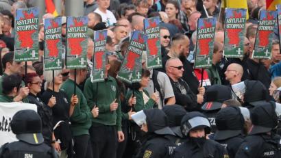 Bild: Jan Woitas/dpa
Rechte Demonstranten stehen am Tag nach den Ausschreitungen vor dem Karl-Marx-Monument in Chemnitz.