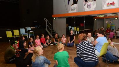 Bild: bey
Erzieherin Ingrid Andes (im Hintergrund Mitte) befragt die Kinder zu Beginn des Workshops nach den Gründen für ihre Tanzbegeisterung.