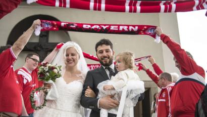 Bild: exb/Zaneta Weiden
Die Mitglieder des Bayern-Fanclubs Neustadt stehen Spalier, als das Brautpaar mit Töchterchen Amelie aus der Kirche kommt.