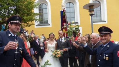Bild: sl
Das Brautpaar Heide Zitzmann und Patrick Fuchs beim Durchschreiten des Rosenspalier der Feuerwehr Lerau mit Vorsitzenden Peter Schwabl (links) und der Vereinsfahne