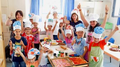 Bild: hai
Jugendbetreuerin Larissa Maier (Zweite von rechts), Anna Burbach (hinten links) und Kathrin Richtmann (hinten Mitte) leiten die Mädchen und Buben bei der Zubereitung von Pizza und Pasta an.
