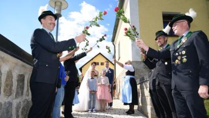 Bild: bey
Mit einem Bogen aus Rosen empfangen die Konnersreuther Schützen das Paar.