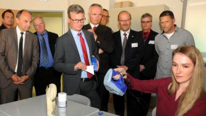 Bild: Stephan Huber
Kultusminister Bernd Sibler (vorne) lässt sich zeigen, wie ein Projektionsscanner ein Bauteil vermisst. Innerhalb von Sekunden landen die Daten auf dem Rechner.