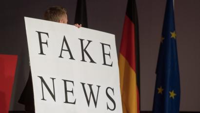 Bild: Marijan Murat/dpa
Ein Mann trägt beim politischen Aschermittwoch der baden-württembergischen CDU heuer im Februar ein Schild mit der Aufschrift „Fake News“.