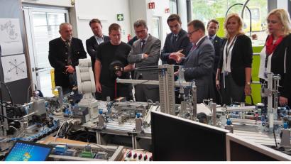 Bild: Bühner
Erich Bauer (Sechster von links) erklärt Kultusminister Bernd Sibler (Vierter von links), was die Festo-Lernfabrik ist.