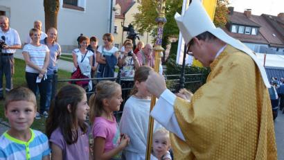 Bild: jr
Weihbischof Dr. Josef Graf segnet Kinder vor der Pfarrkirche.
