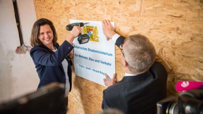 Bild: Lino Mirgeler/dpa
Ilse Aigner, Bau- und Verkehrsministerin von Bayern, schraubt Ende März neben Helmut Schütz, Ministerialdirektor, auf der Baustelle des neuen Bauministeriums ein symbolisches Schild des Ministeriums an die Wand. Aigner stellte ihr Programm am Donnerstag im Wirtschaftsausschuss des Landtags vor.